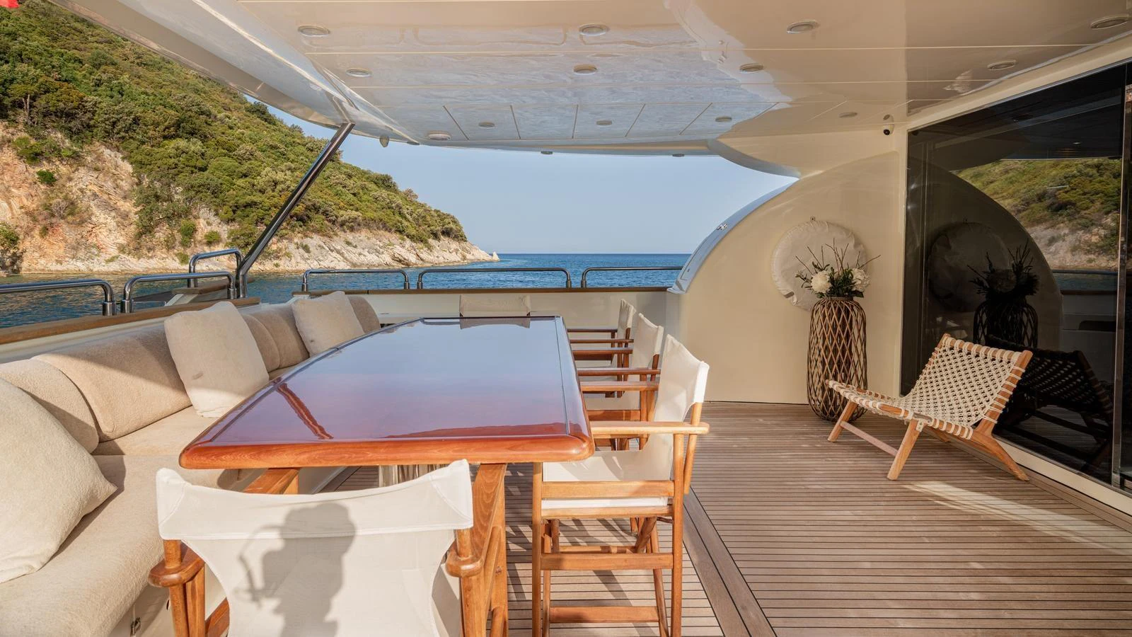 The aft deck features a spacious dining area with comfortable seating and stunning views of the surrounding landscape. aboard LIMION Yacht for Sale