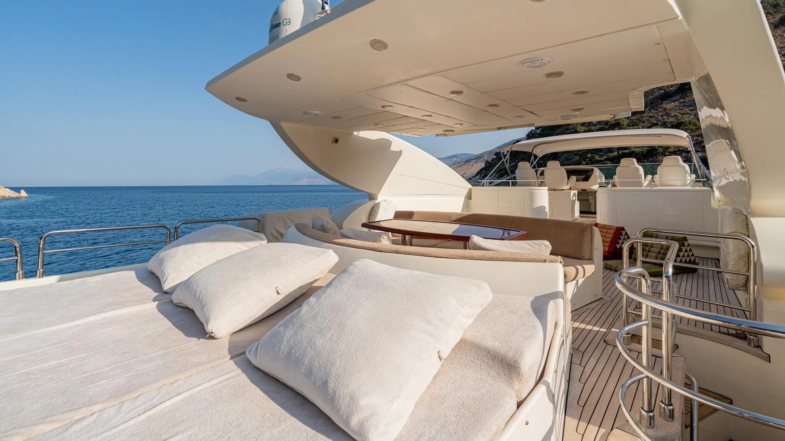 The flybridge offers a spacious lounging area with plush cushions and stunning sea views. aboard LIMION Yacht for Sale
