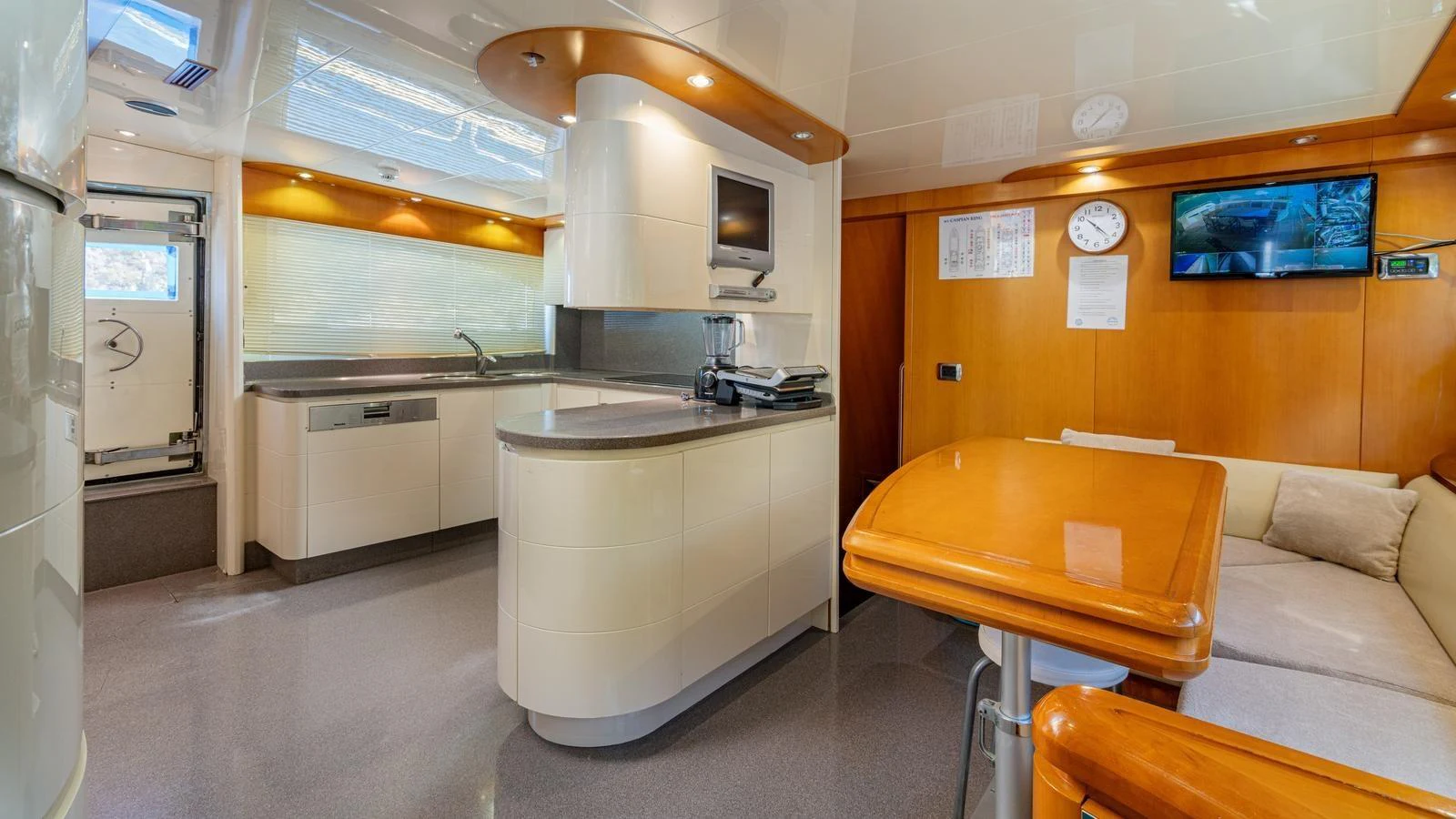 The yacht's galley features modern appliances and a cozy dining area with warm wood accents. aboard LIMION Yacht for Sale