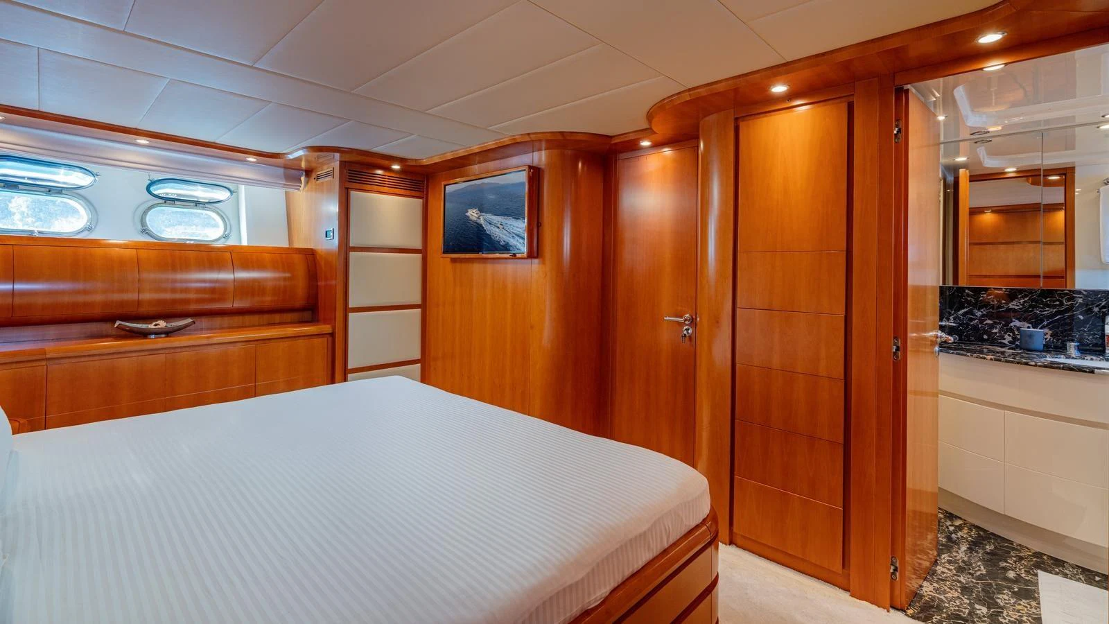 The master stateroom features elegant wood paneling and a plush bed, creating a luxurious and inviting atmosphere. aboard LIMION Yacht for Sale