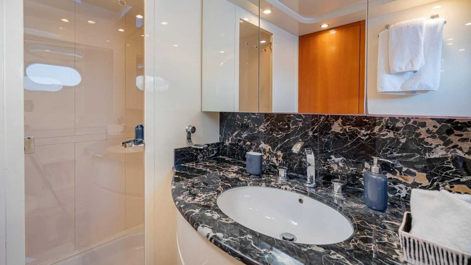 The bathroom features a sleek design with a marble countertop and modern fixtures. aboard LIMION Yacht for Sale