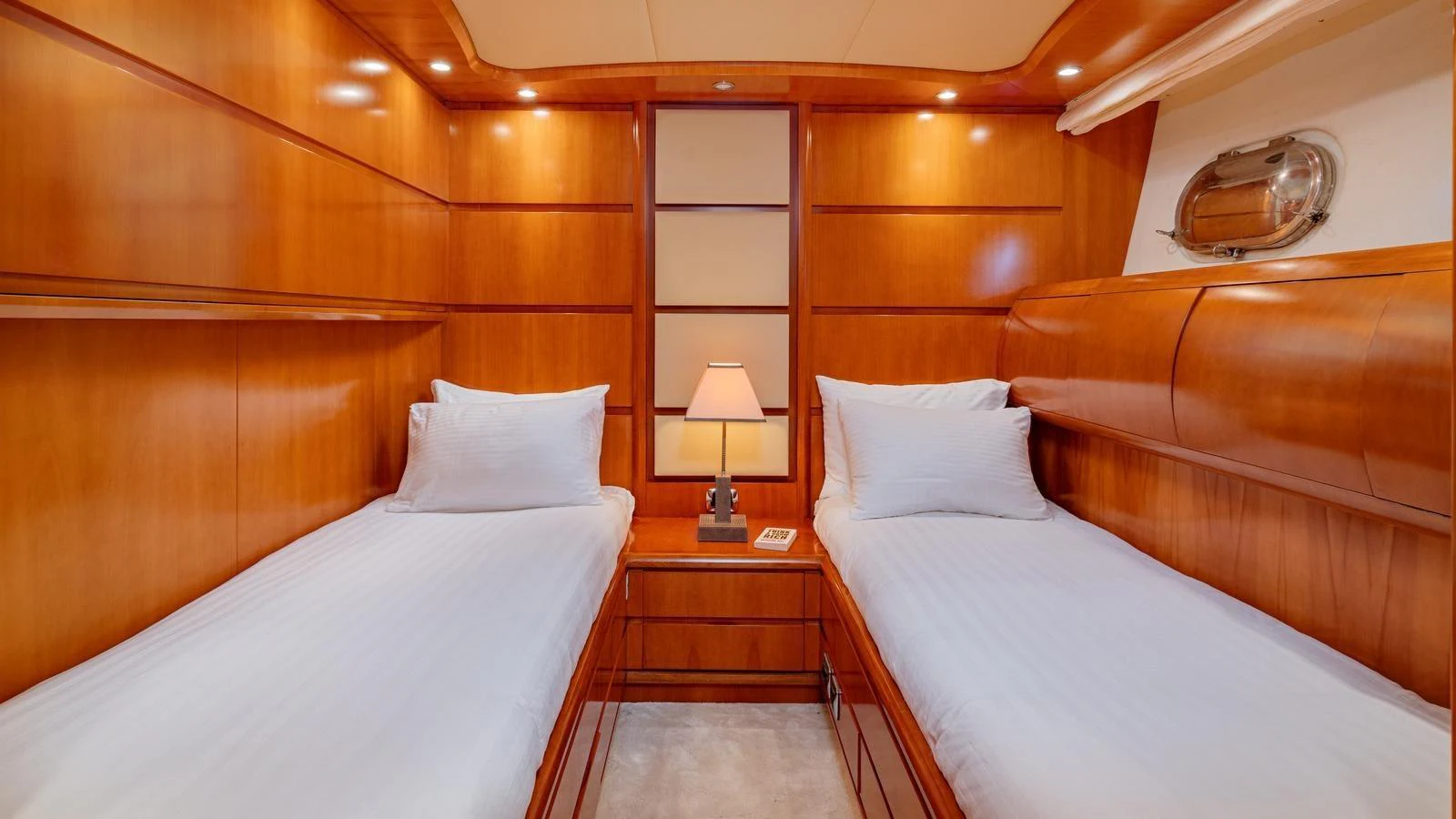 The twin stateroom features warm wooden paneling and cozy twin beds with crisp white linens. aboard LIMION Yacht for Sale