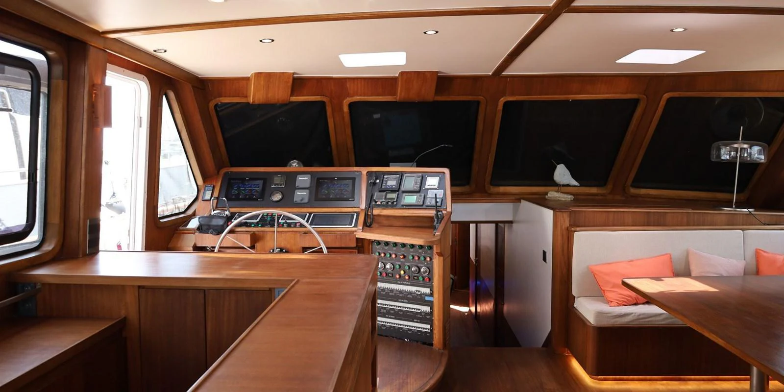 The helm station features a sophisticated control panel with comfortable seating and a warm wooden finish. aboard AKHENATON Yacht for Sale