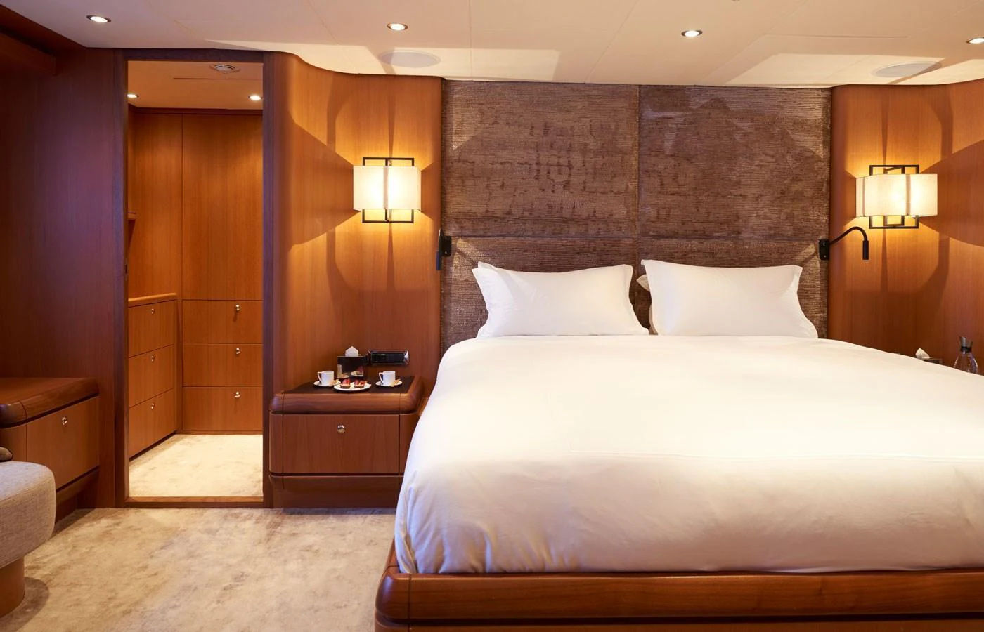 The master stateroom features a luxurious bed with elegant lighting and warm wooden accents. aboard GALENA Yacht for Sale