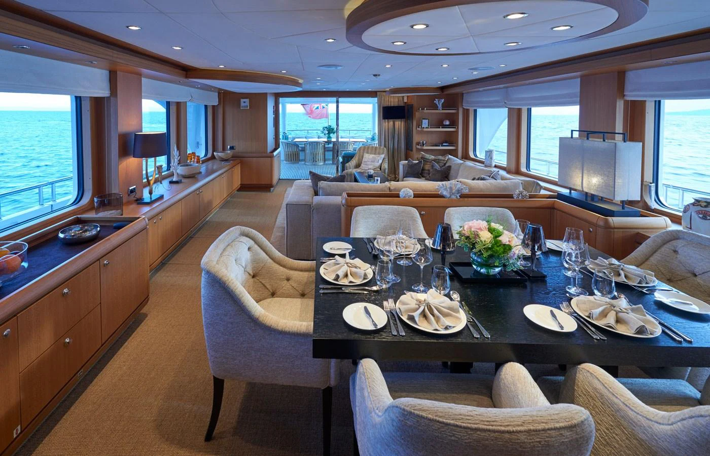 The yacht's dining area features elegant table settings and plush seating with expansive ocean views. aboard GALENA Yacht for Sale