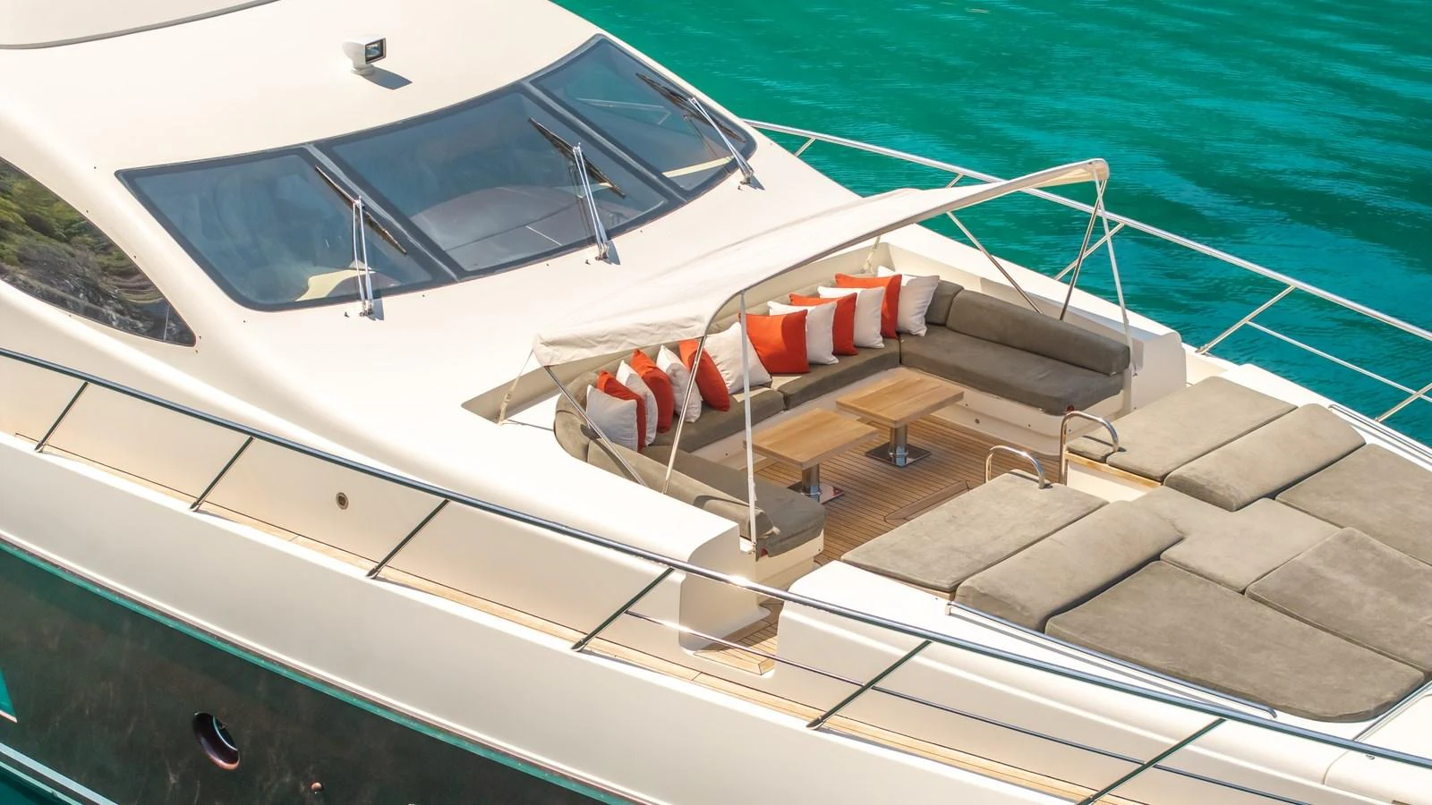 The foredeck features a spacious sunbathing area with plush cushions and a shaded seating arrangement. aboard EROSSEA Yacht for Sale