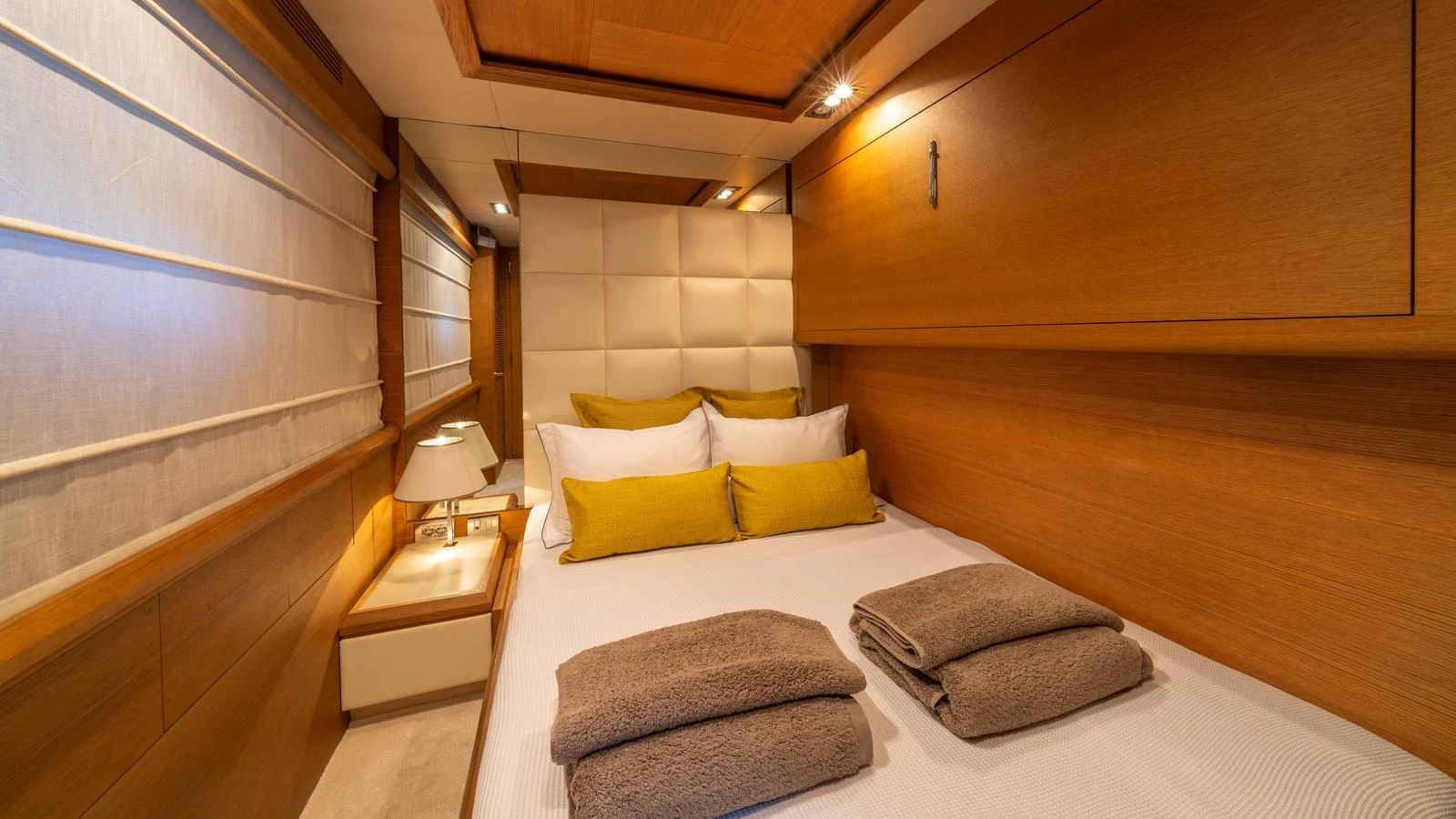 The stateroom features a cozy bed with plush linens and warm wooden accents. aboard EROSSEA Yacht for Sale