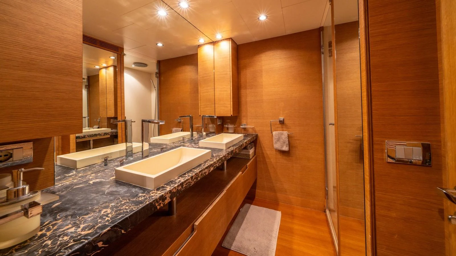 The yacht's bathroom features a luxurious double sink vanity with elegant fixtures and warm wood finishes. aboard EROSSEA Yacht for Sale