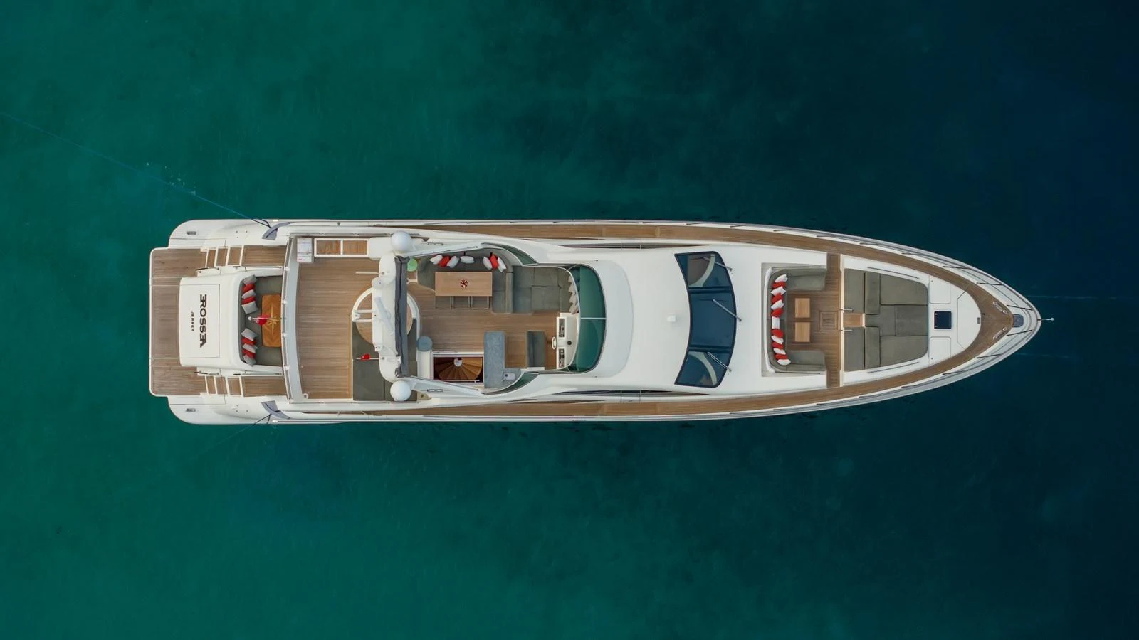 A stunning aerial view of a sleek yacht cruising through clear blue waters. aboard EROSSEA Yacht for Sale