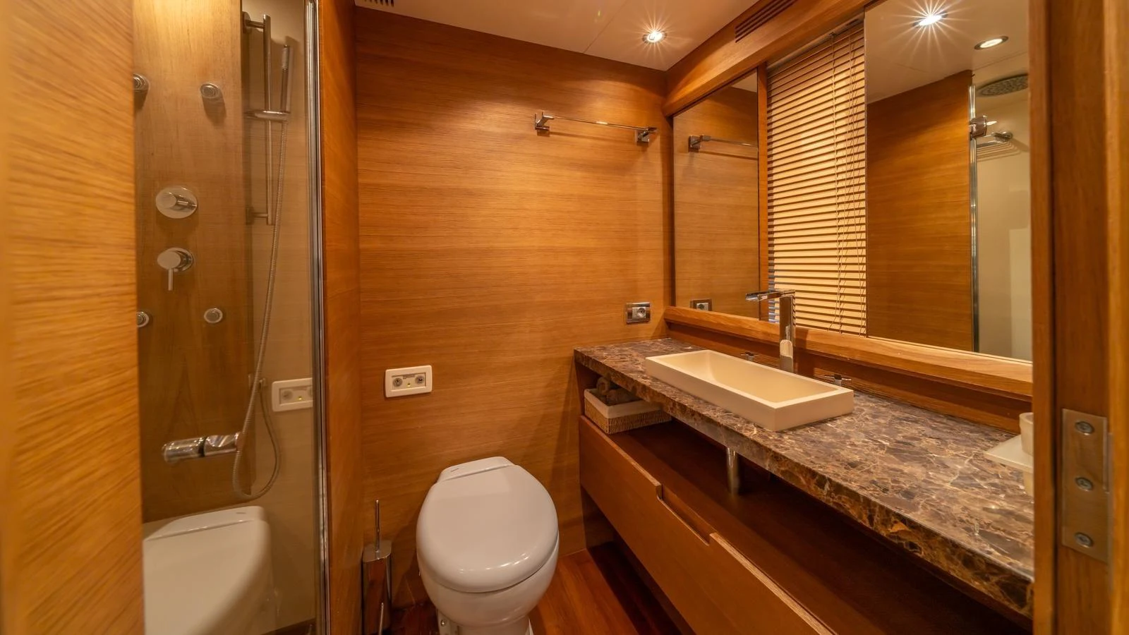 The yacht's bathroom features a sleek design with wooden accents and modern fixtures. aboard EROSSEA Yacht for Sale