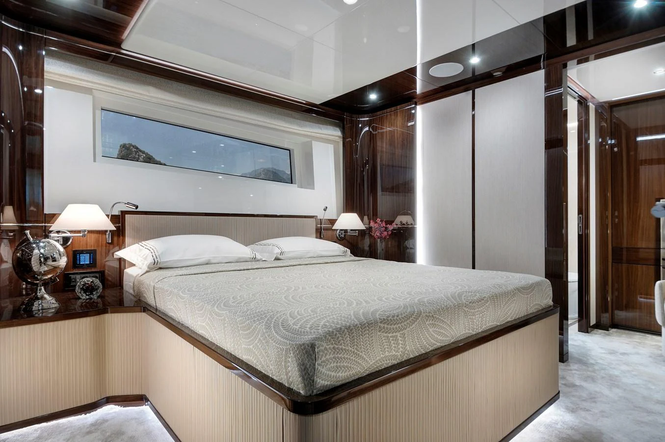 The master stateroom features a luxurious bed with elegant lighting and modern decor. aboard LAZZARA UHV 90 Yacht for Sale