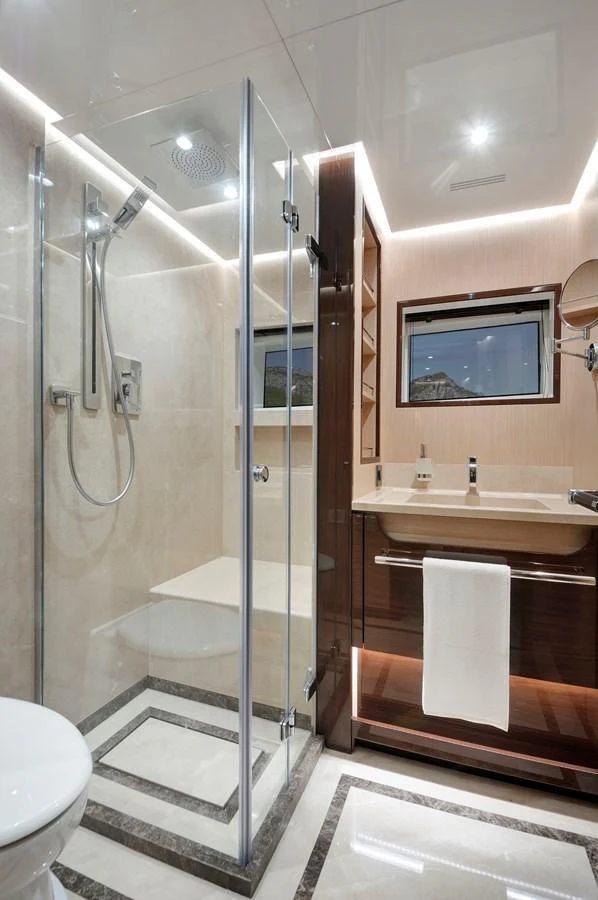 A luxurious yacht bathroom featuring a glass-enclosed shower and elegant fixtures. aboard LAZZARA UHV 90 Yacht for Sale