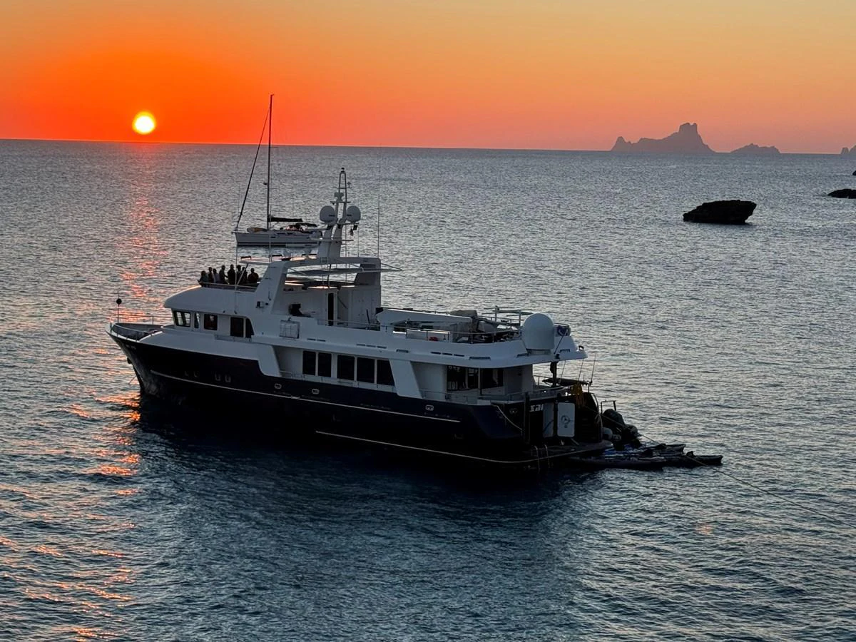 A luxurious yacht cruises at sunset, creating a serene and picturesque scene on the water. aboard SAMSARA Yacht for Sale