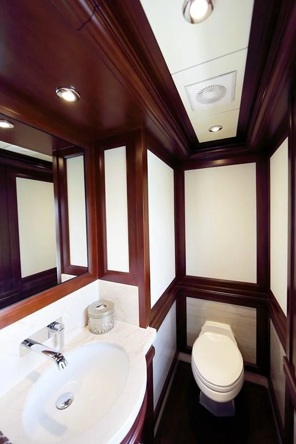 A luxurious yacht bathroom with elegant wood paneling and modern fixtures. aboard SAMSARA Yacht for Sale