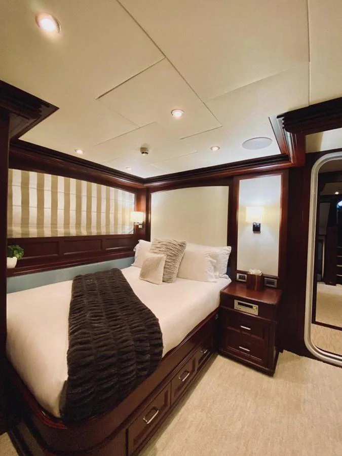 A cozy and elegant stateroom featuring a plush bed with luxurious linens and warm lighting. aboard SAMSARA Yacht for Sale