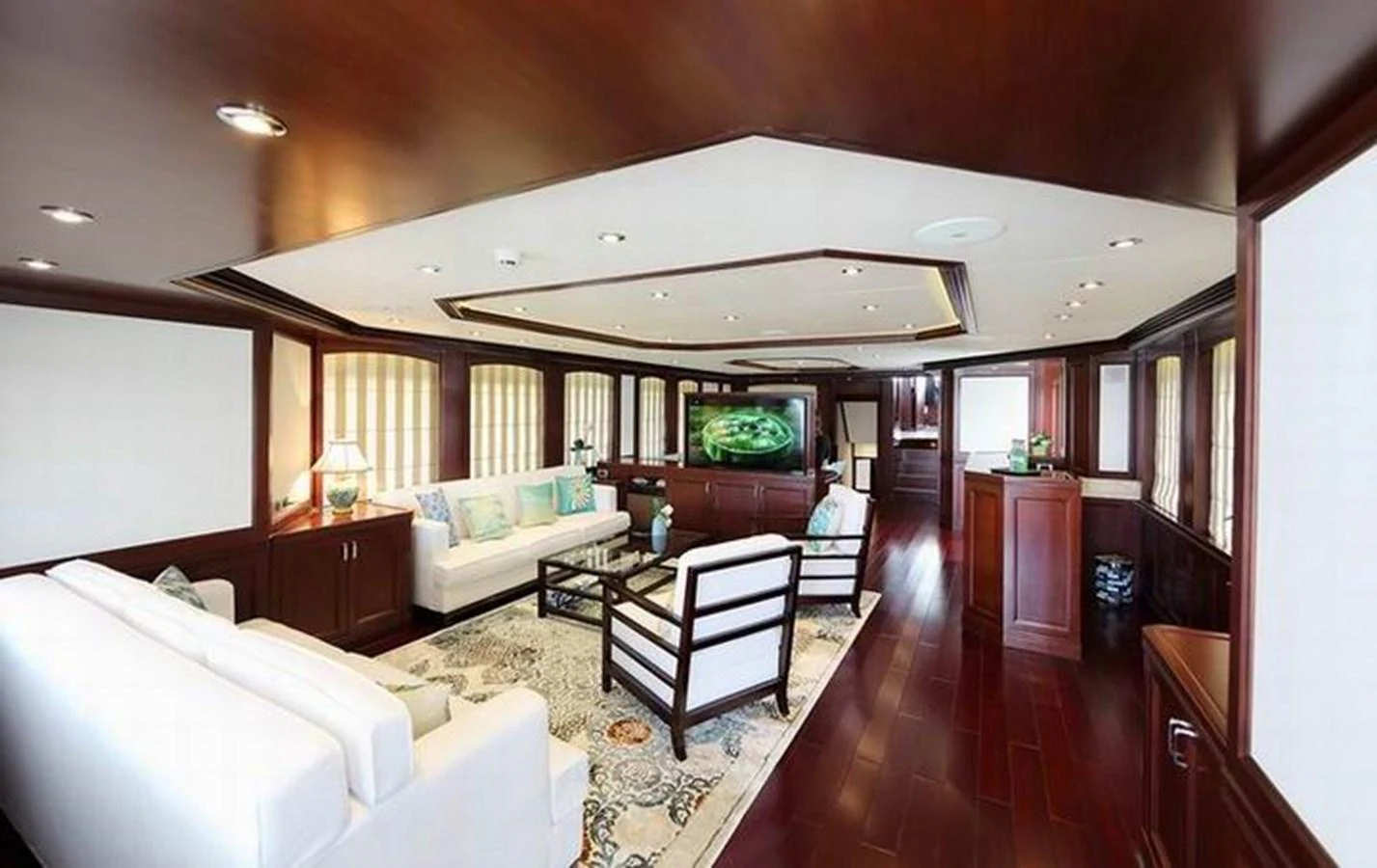 The yacht's salon features elegant wood paneling, plush seating, and a large flat-screen TV for entertainment. aboard SAMSARA Yacht for Sale