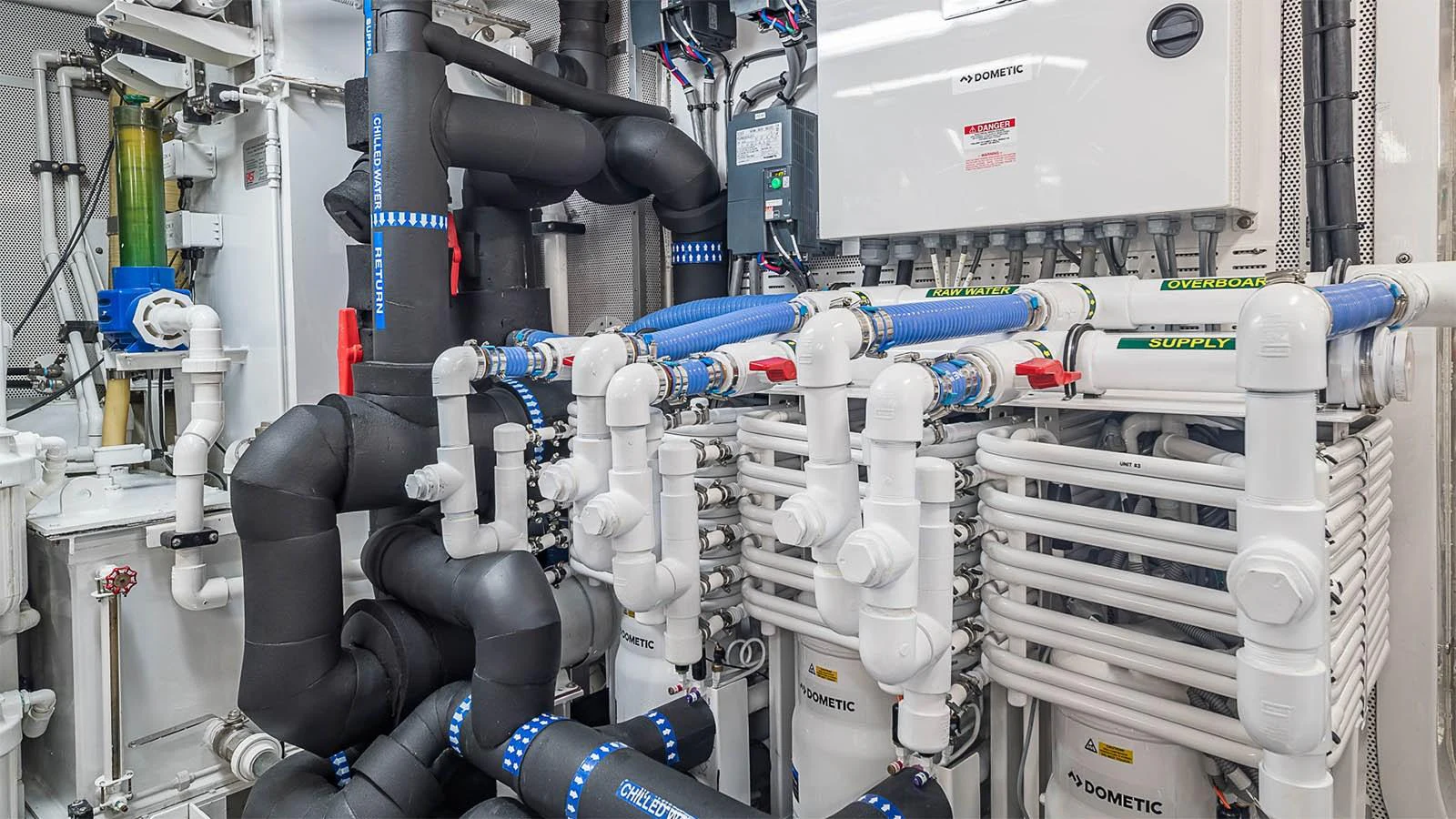 The image showcases the yacht's engine room with a complex array of pipes and machinery. aboard CARTE BLANCHE Yacht for Sale