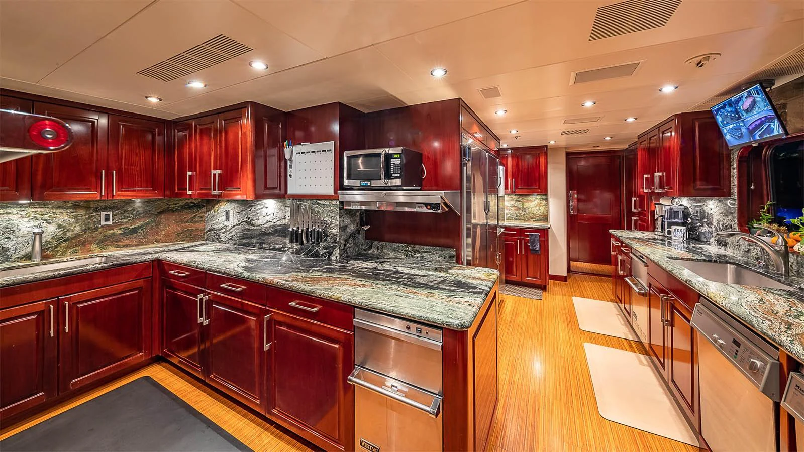 The yacht's galley features rich wooden cabinetry, modern appliances, and ample counter space. aboard CARTE BLANCHE Yacht for Sale