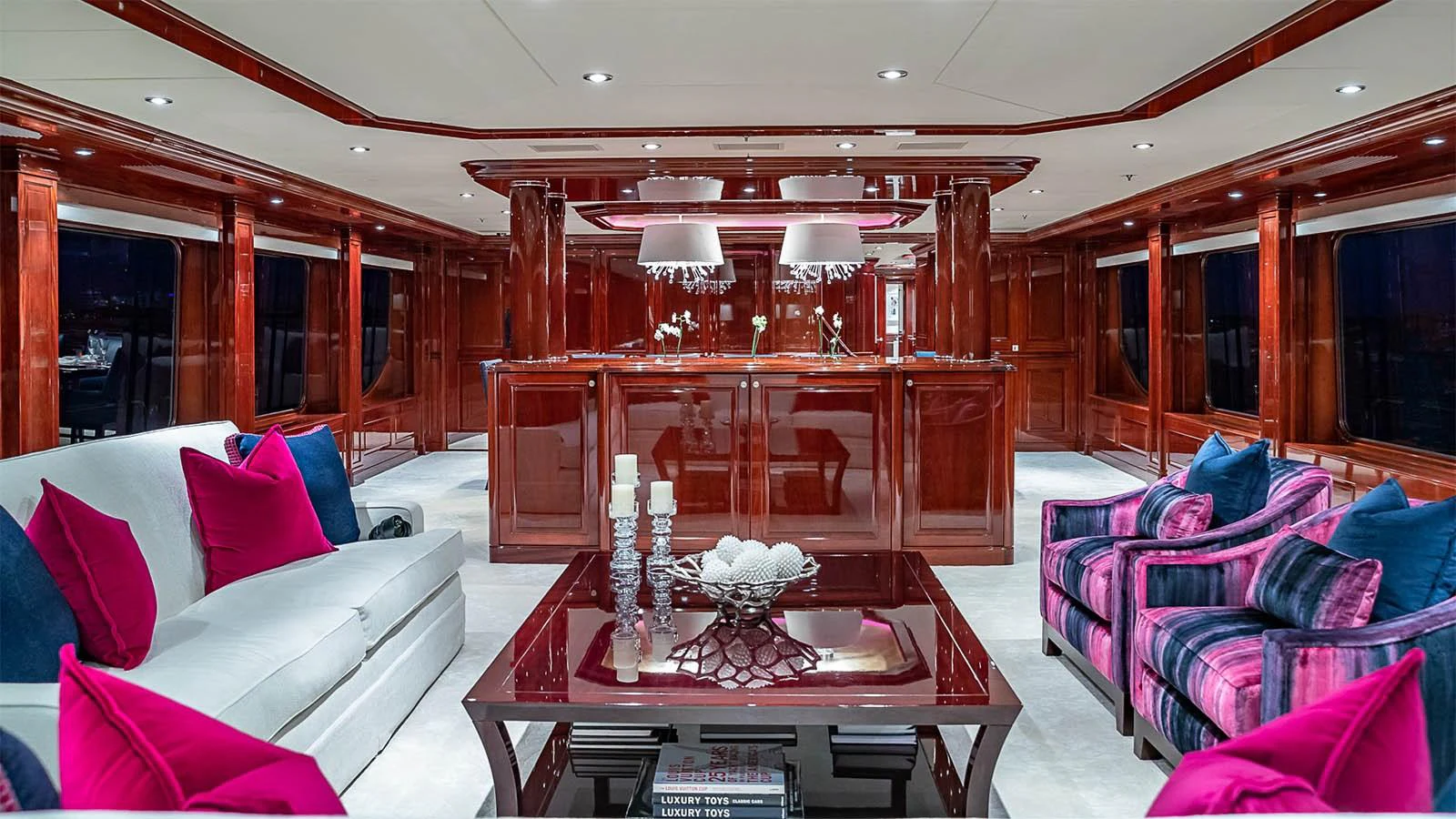 The yacht's salon features luxurious seating with vibrant accents and a polished wooden finish. aboard CARTE BLANCHE Yacht for Sale