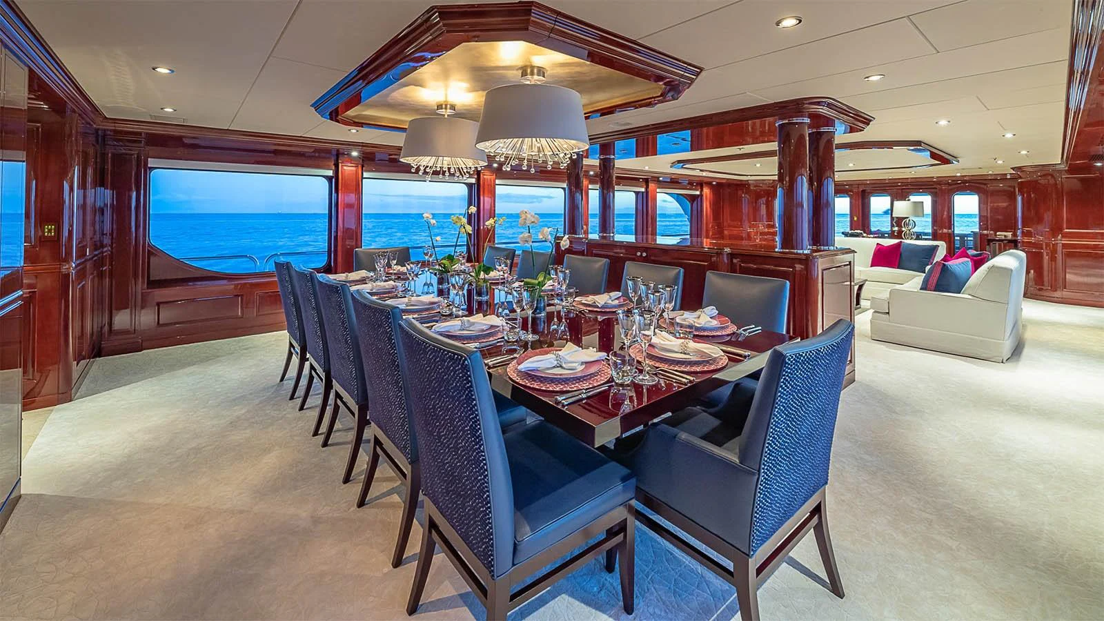 The yacht's dining area features a luxurious table setting with panoramic ocean views. aboard CARTE BLANCHE Yacht for Sale