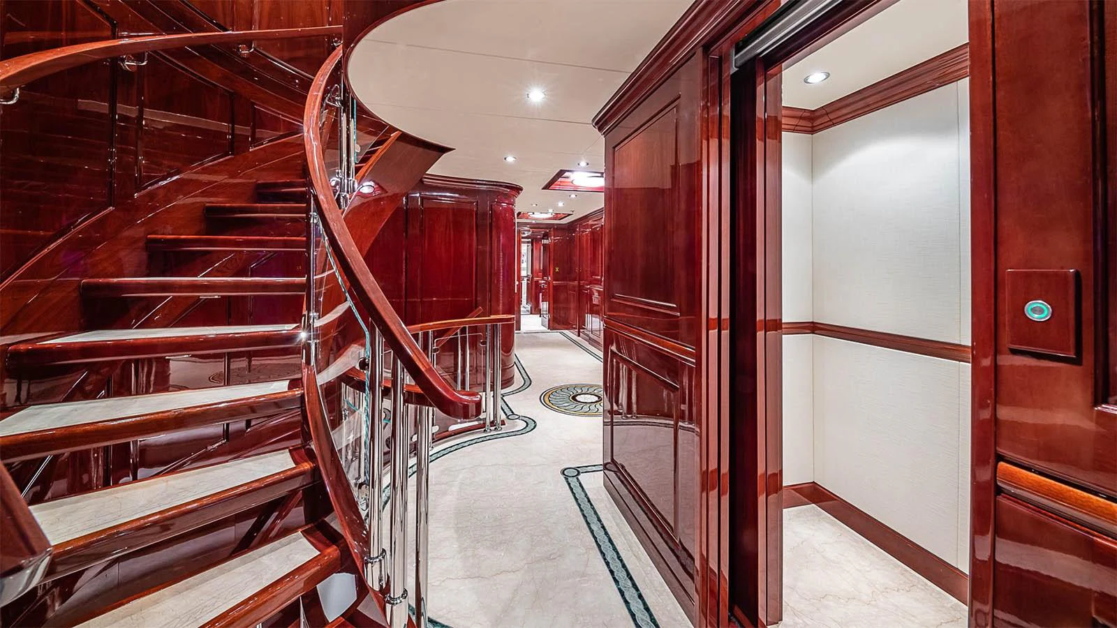 The yacht's interior features a beautifully crafted wooden staircase with elegant railings and luxurious finishes. aboard CARTE BLANCHE Yacht for Sale