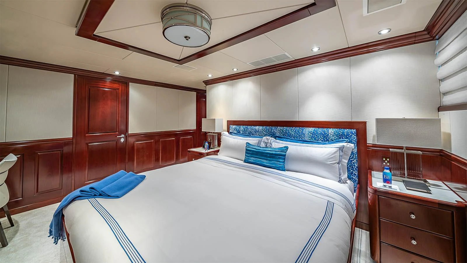 The master stateroom features a luxurious king-sized bed with elegant wood paneling and modern lighting. aboard CARTE BLANCHE Yacht for Sale