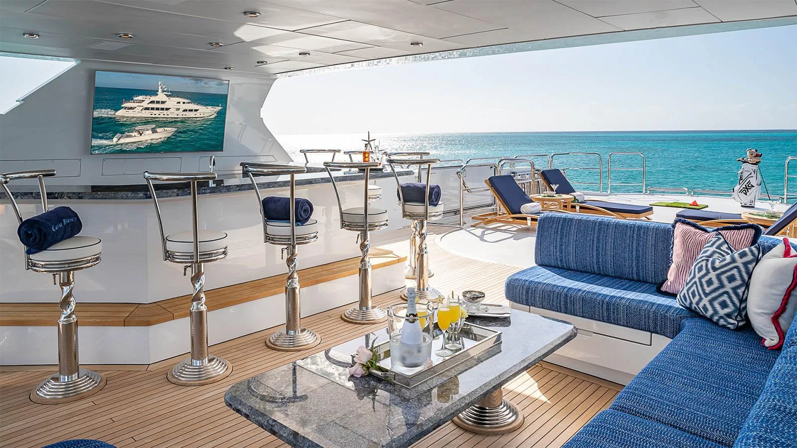 The aft deck features a luxurious bar area with seating and a comfortable lounge overlooking the ocean. aboard CARTE BLANCHE Yacht for Sale