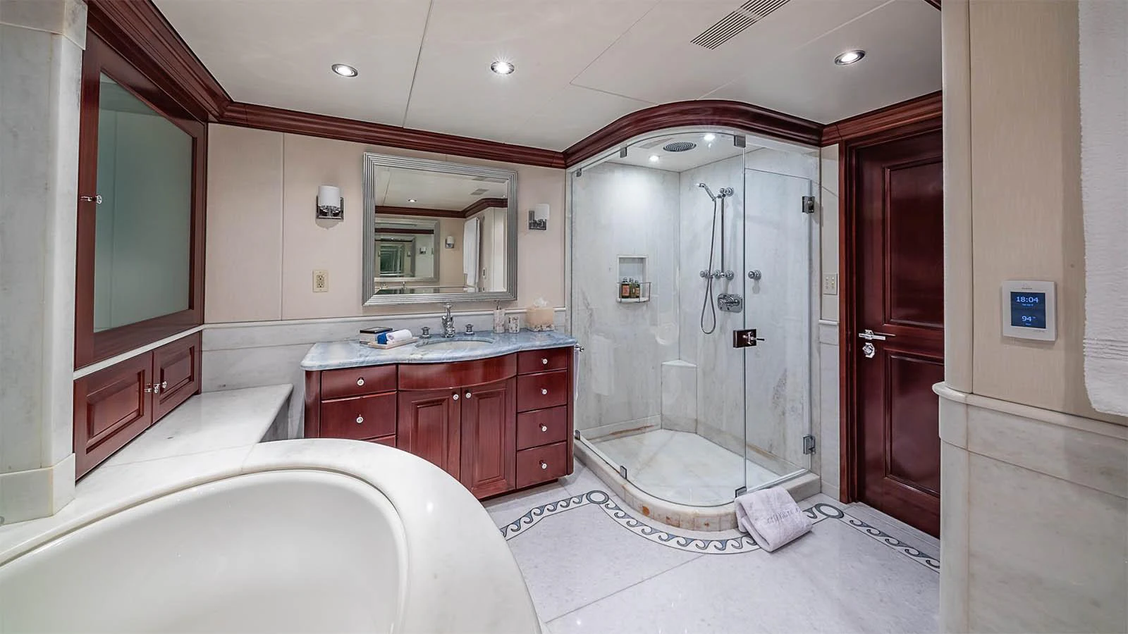 The yacht's bathroom features elegant wood cabinetry, a spacious shower, and luxurious marble finishes. aboard CARTE BLANCHE Yacht for Sale