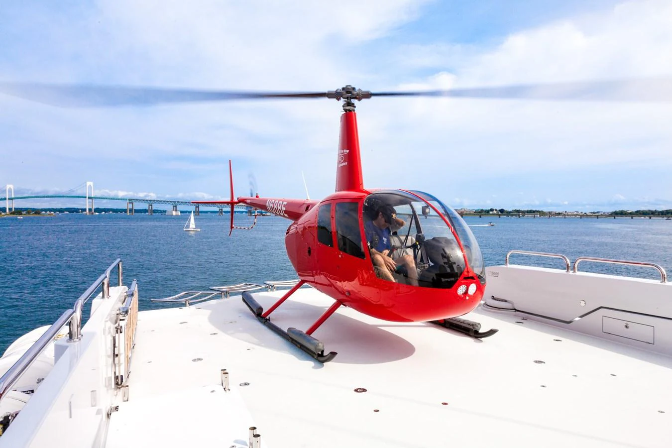 A sleek red helicopter is parked on the yacht's helipad, ready for an adventure. aboard CARTE BLANCHE Yacht for Sale
