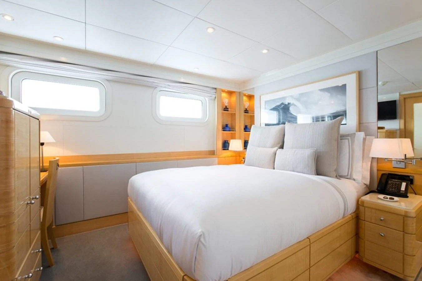 The stateroom features a plush bed, ample natural light, and elegant wood finishes. aboard LA TANIA Yacht for Sale