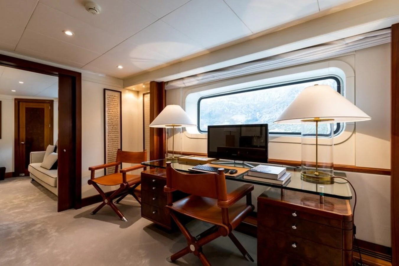 The yacht's office features elegant wooden furniture and a large window with a scenic view. aboard LA TANIA Yacht for Sale