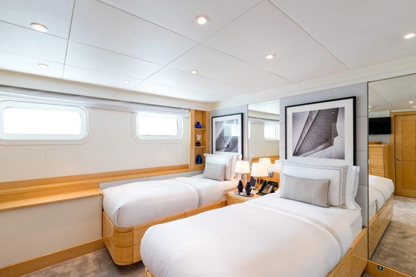 The guest stateroom features twin beds, elegant decor, and ample natural light from the windows. aboard LA TANIA Yacht for Sale