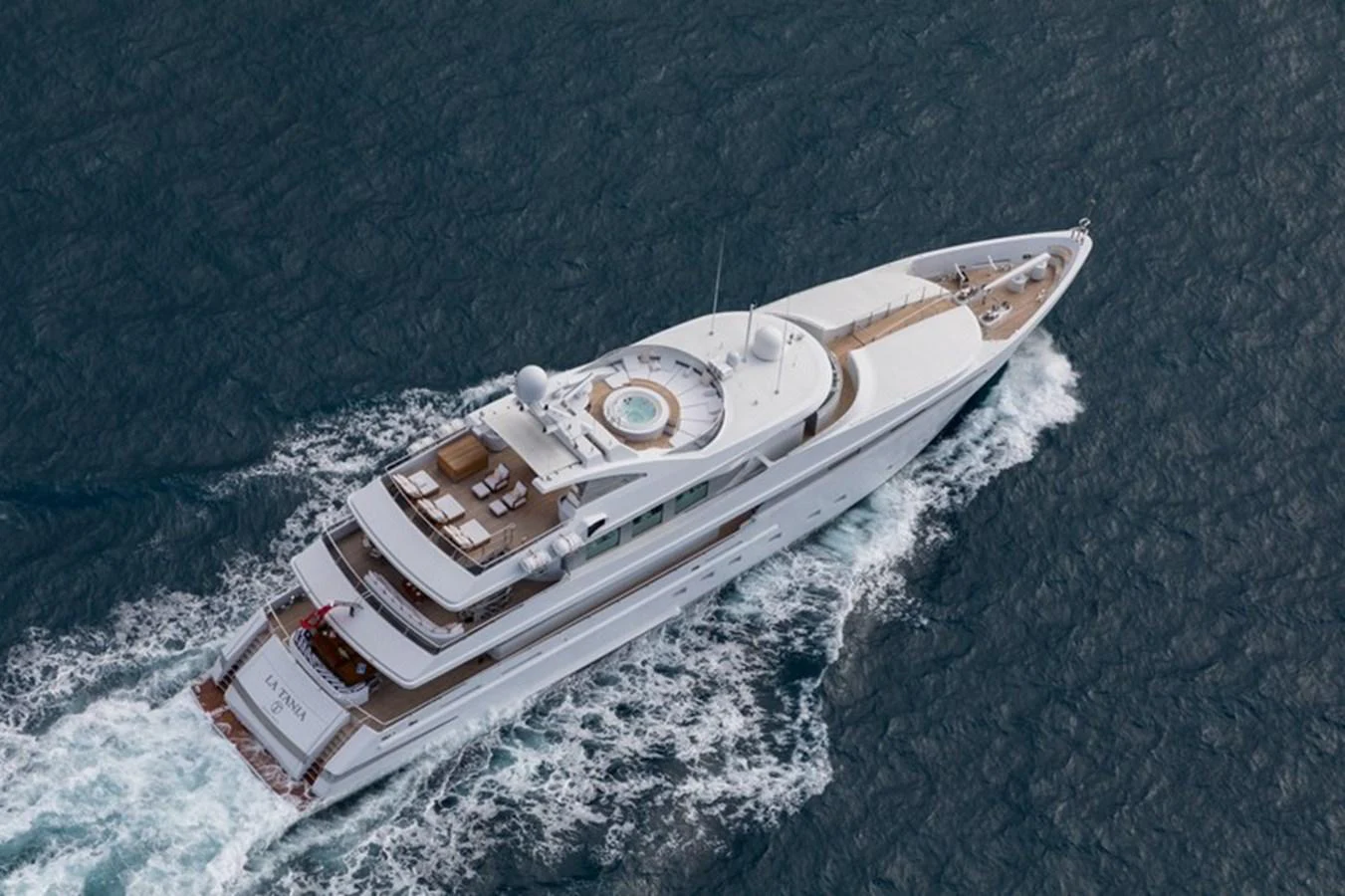 A luxurious yacht cruises through the open water, showcasing its elegant design and spacious decks. aboard LA TANIA Yacht for Sale