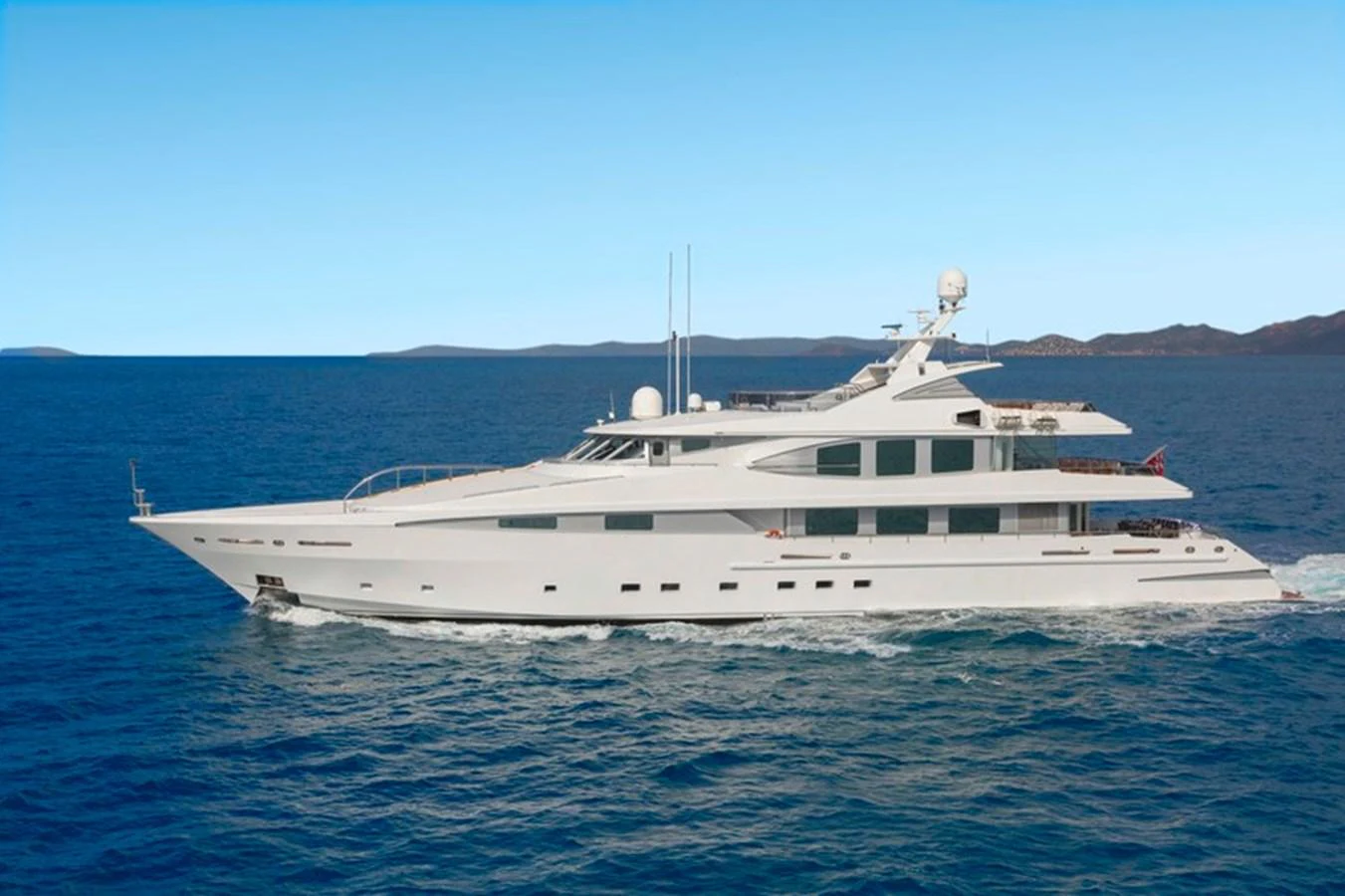 A sleek and modern yacht cruises gracefully on the open sea under a clear blue sky. aboard LA TANIA Yacht for Sale