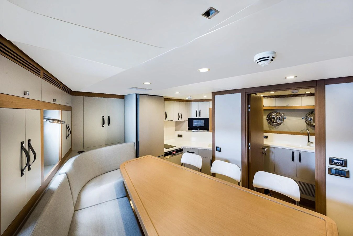 The yacht's galley features a modern dining area with ample seating and sleek cabinetry. aboard CMB47-107 Yacht for Sale