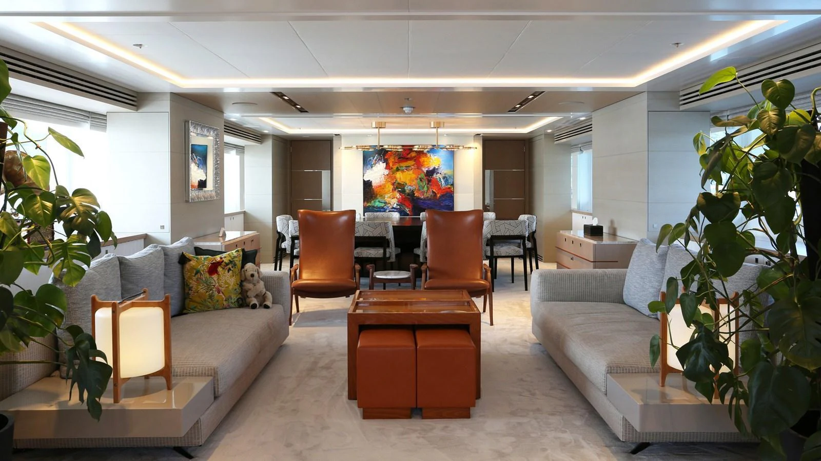 The salon features luxurious seating, modern decor, and vibrant artwork, creating an inviting and elegant atmosphere. aboard HEESEN 47M Yacht for Sale