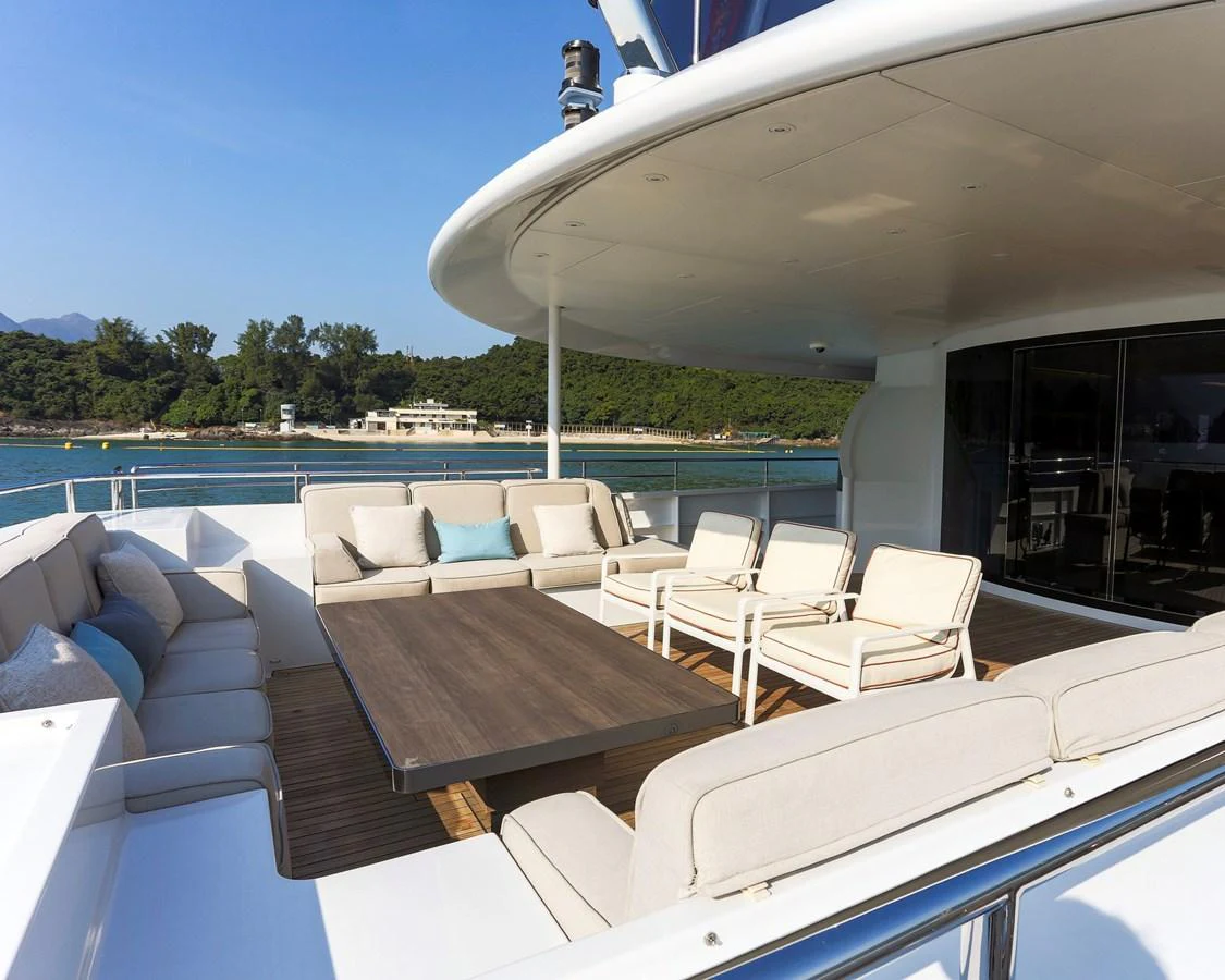 The aft deck offers a spacious and inviting outdoor seating area with plush sofas and a large table, perfect for relaxation and socializing. aboard HEESEN 47M Yacht for Sale