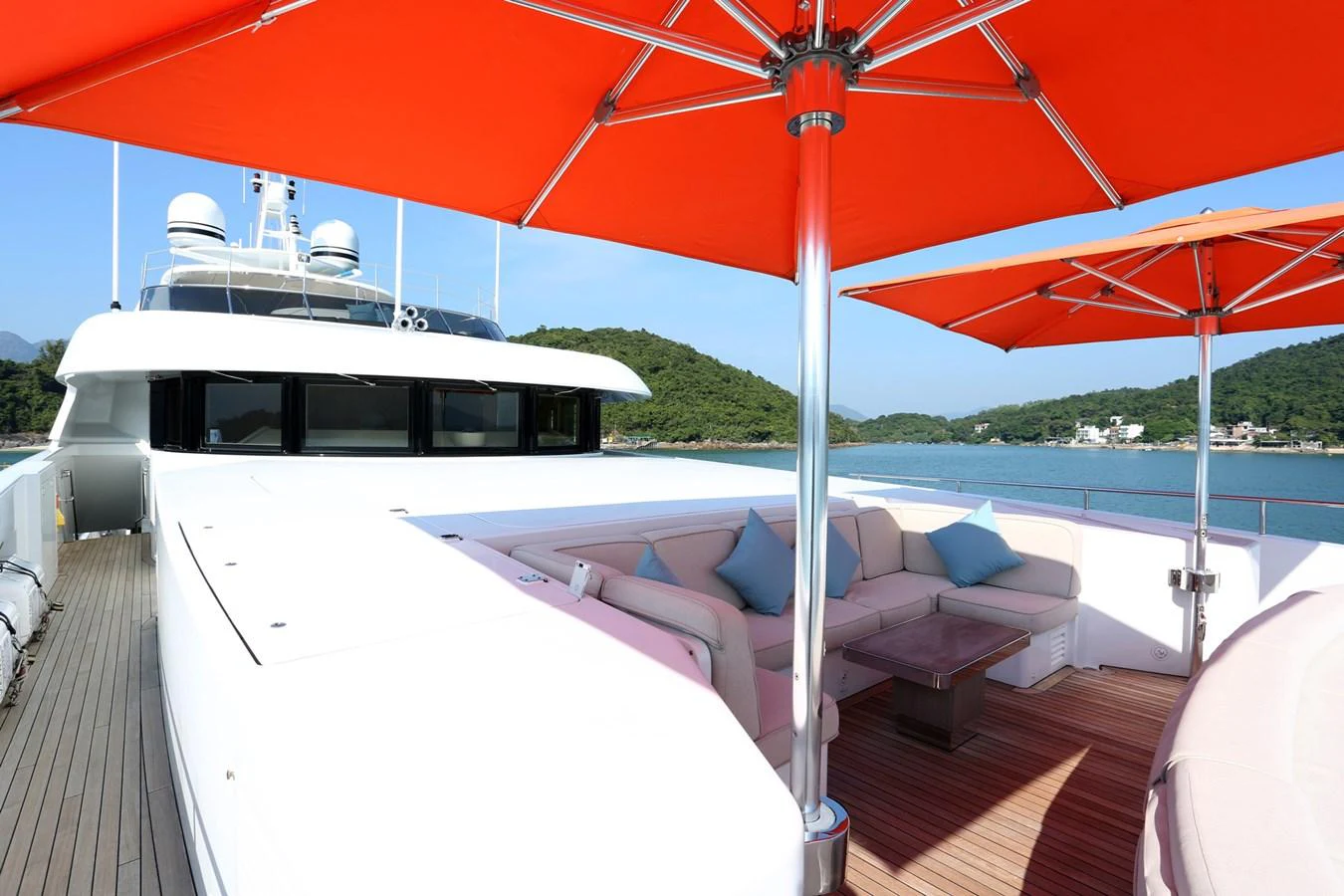 The flybridge offers a spacious seating area with vibrant red umbrellas providing shade. aboard HEESEN 47M Yacht for Sale