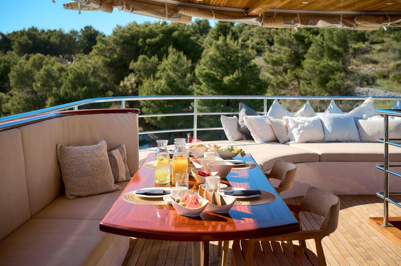 The alfresco dining area offers a serene and inviting space for meals with a view of lush greenery. aboard BELLEZZA Yacht for Sale