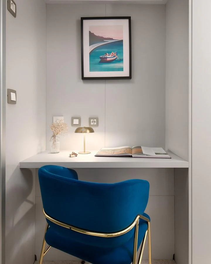 A cozy workspace with a blue chair and a desk lamp, perfect for productivity on board. aboard BELLEZZA Yacht for Sale