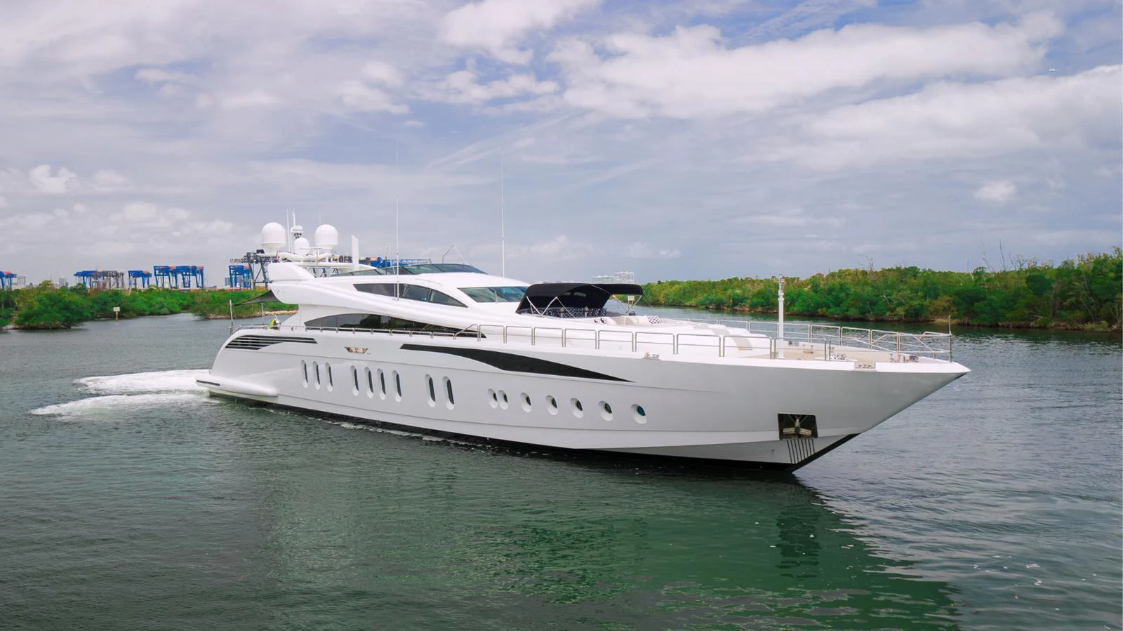 A sleek and modern yacht cruises gracefully on calm waters under a partly cloudy sky. aboard BET ON IT Yacht for Sale