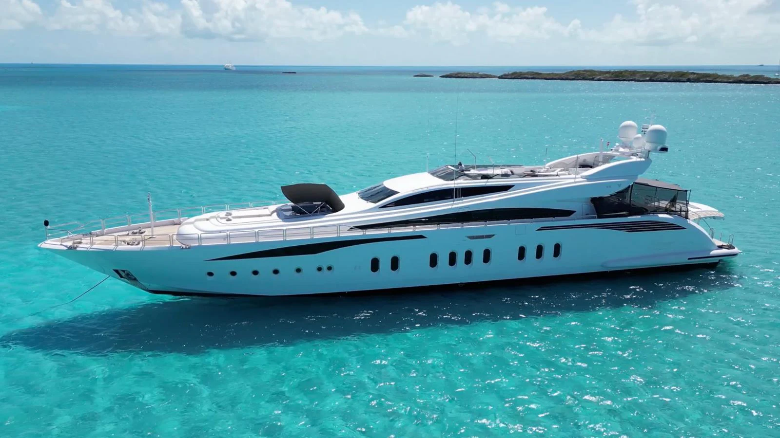 A sleek, modern yacht glides gracefully on turquoise waters under a clear sky. aboard BET ON IT Yacht for Sale