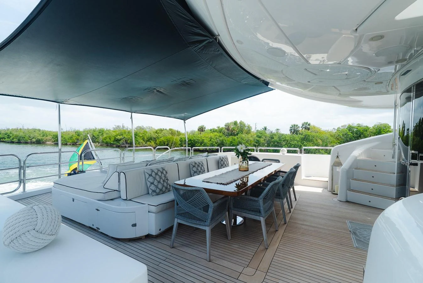 The aft deck offers a spacious and shaded outdoor dining area with comfortable seating and scenic views. aboard BET ON IT Yacht for Sale