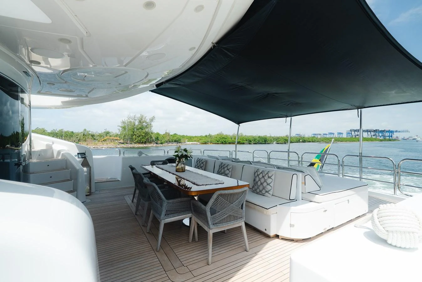 The aft deck offers a spacious and shaded outdoor dining area with comfortable seating and scenic views. aboard BET ON IT Yacht for Sale