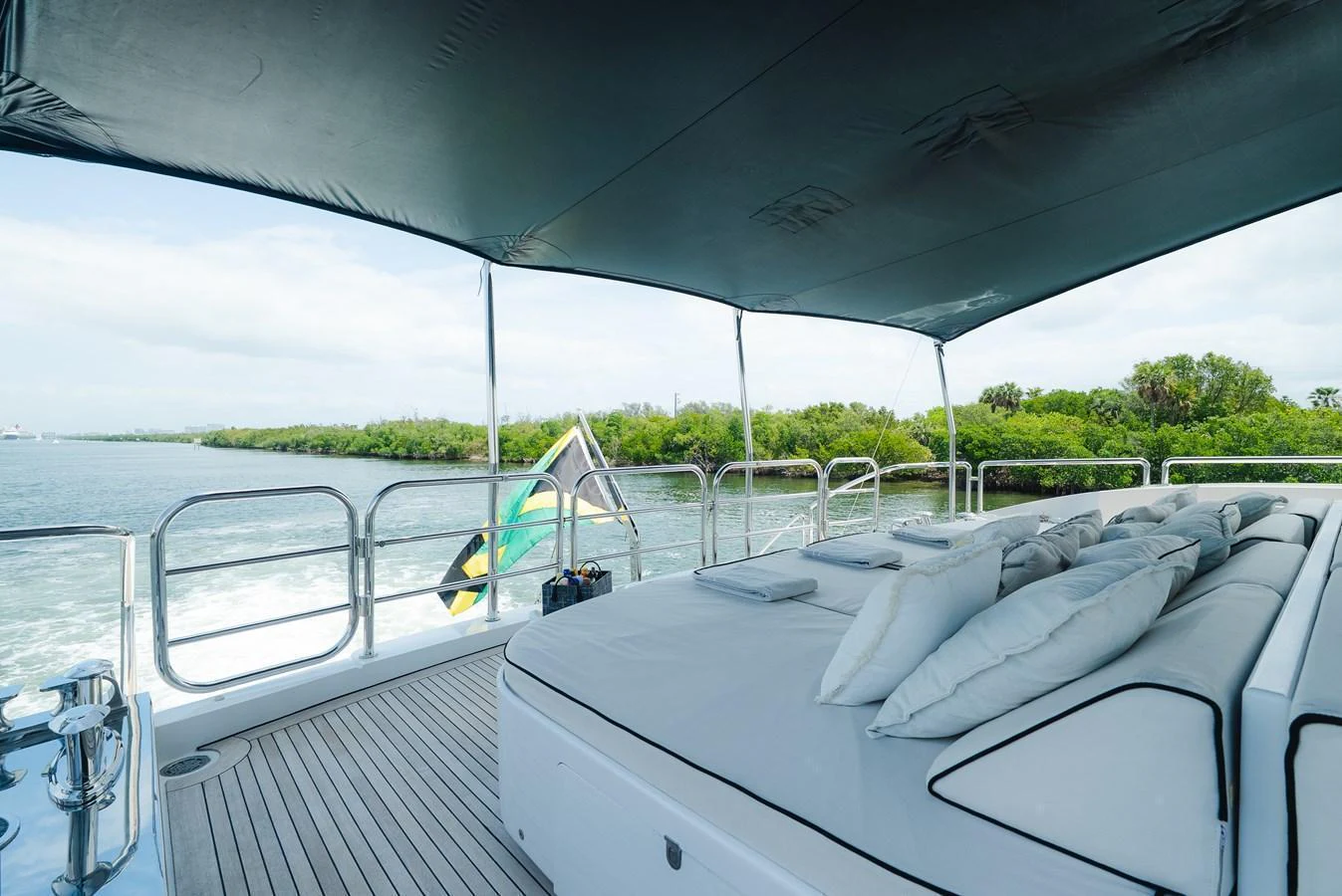 The sundeck features a luxurious lounging area with plush cushions and a shaded canopy, offering a perfect spot to relax while enjoying the scenic views. aboard BET ON IT Yacht for Sale