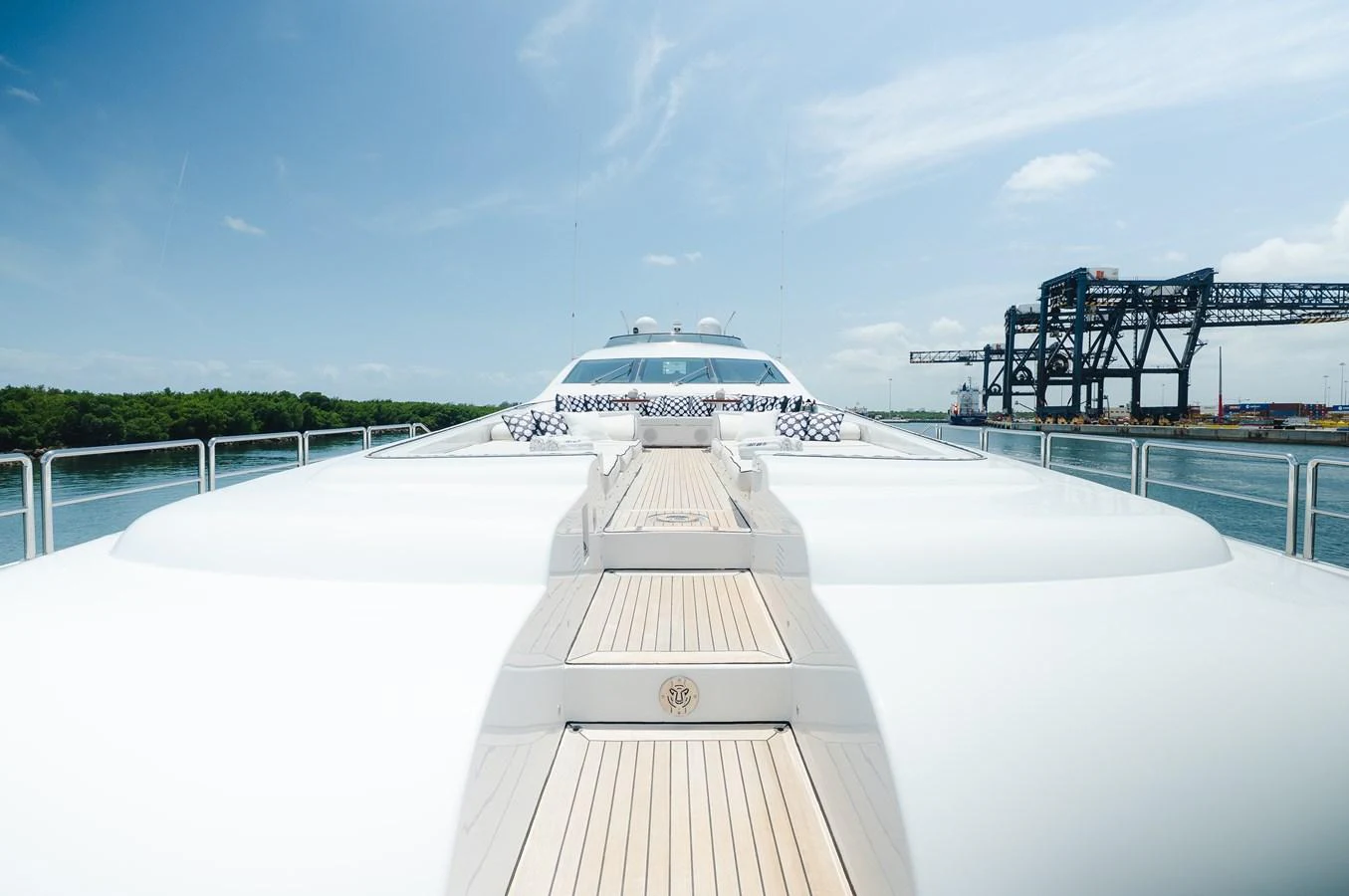 The yacht's sleek deck stretches forward under a clear blue sky, showcasing its modern design. aboard BET ON IT Yacht for Sale