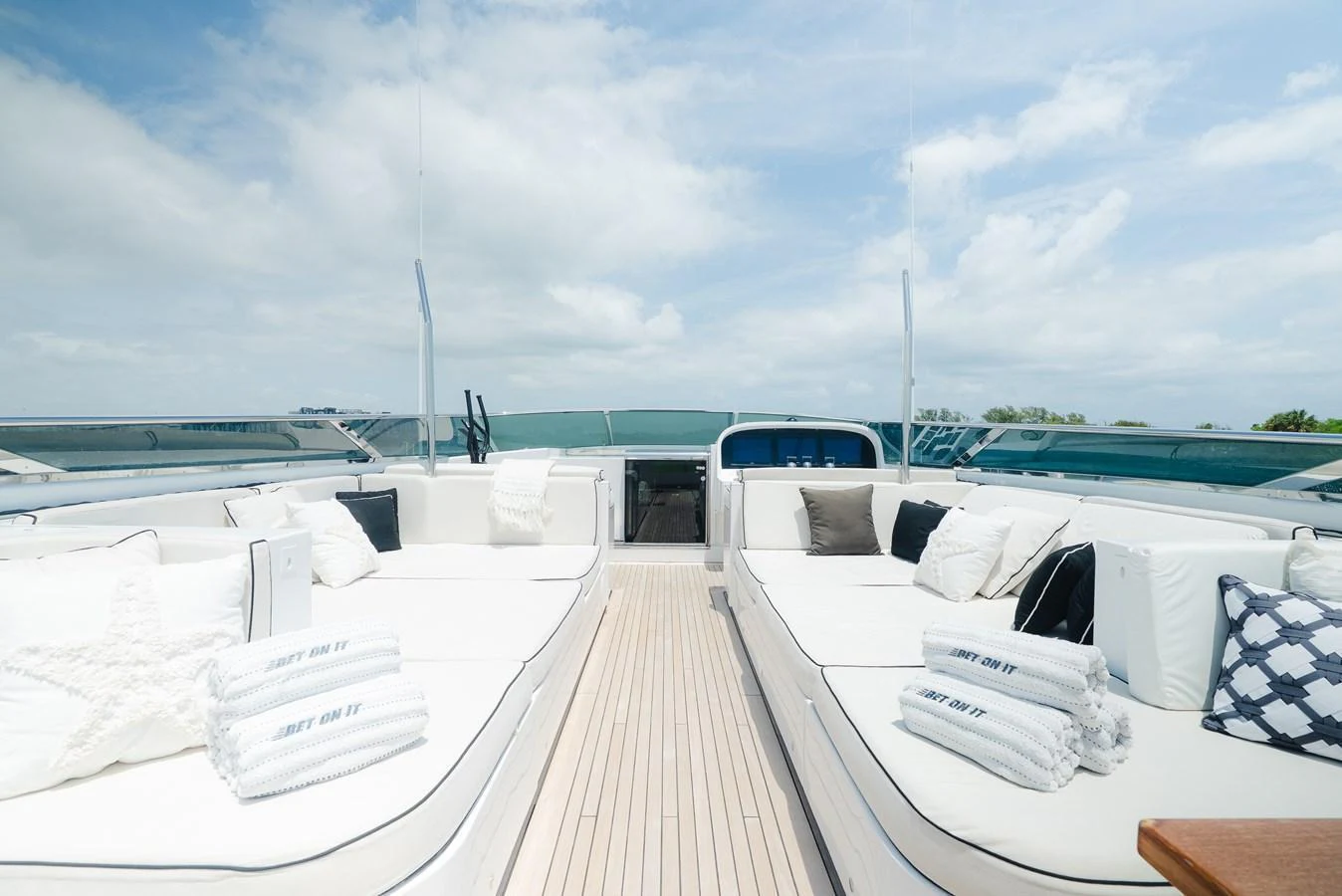 The sundeck features luxurious sun loungers with plush cushions and towels, perfect for relaxation under the sky. aboard BET ON IT Yacht for Sale