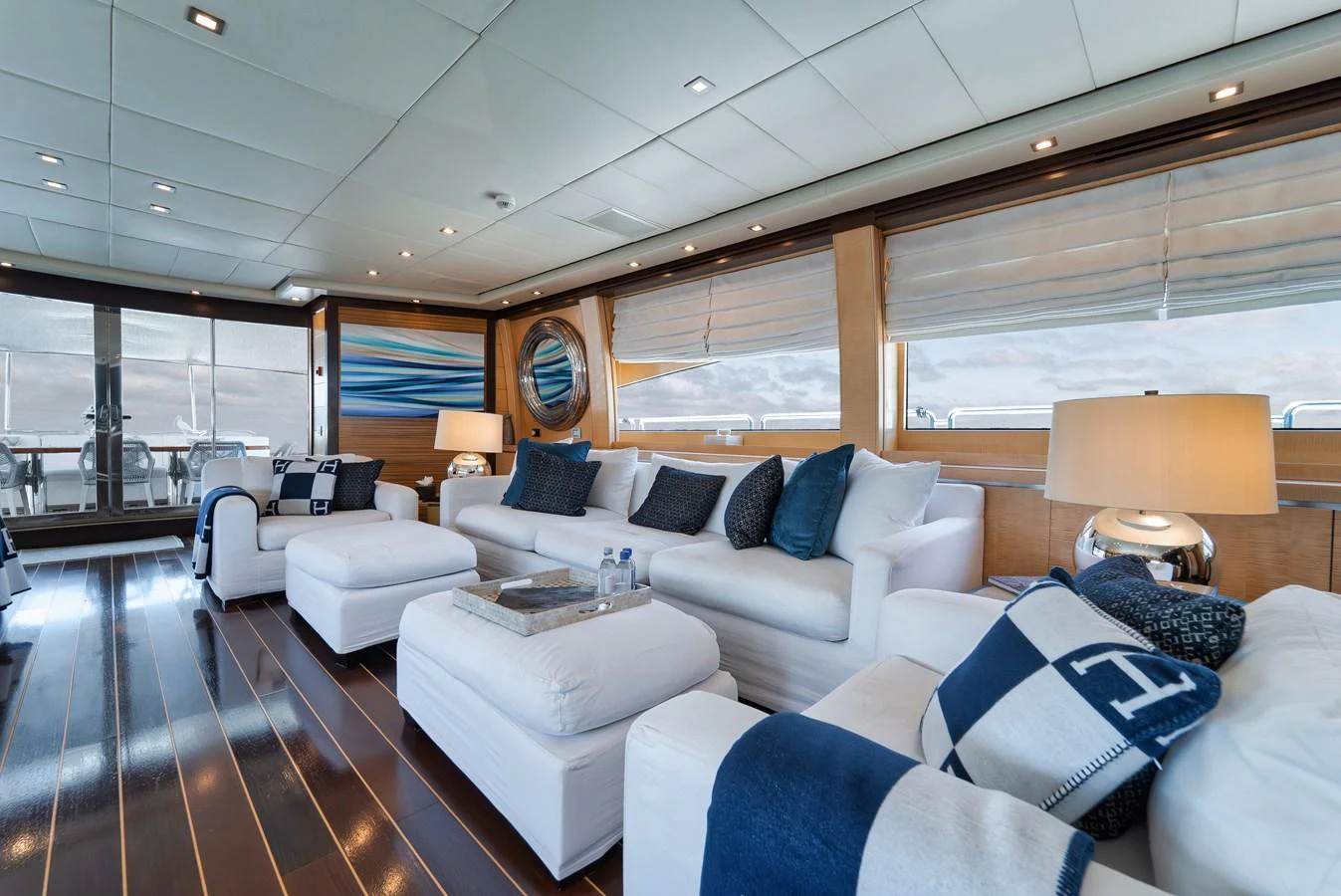 The salon features plush white seating, elegant decor, and ample natural light. aboard BET ON IT Yacht for Sale