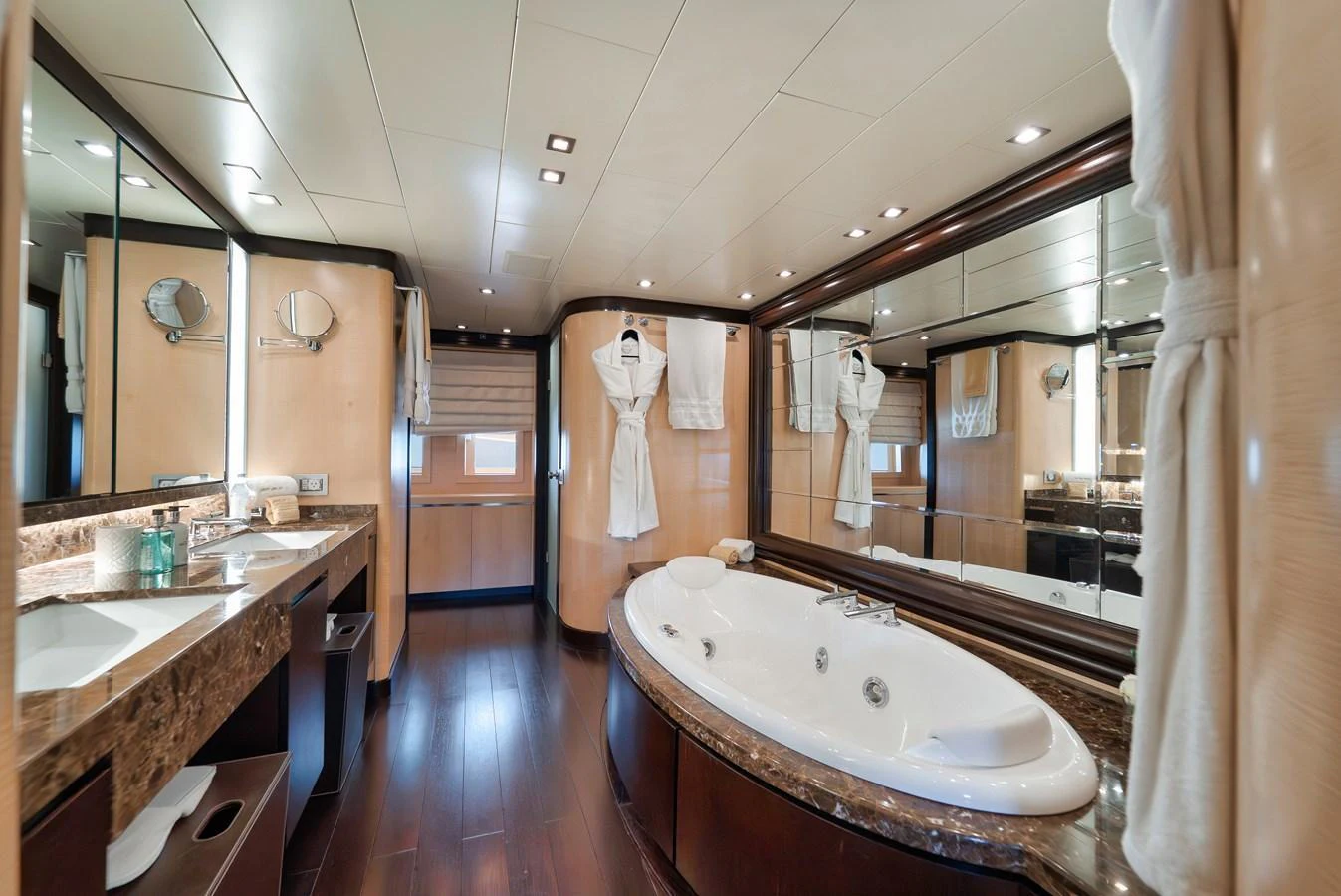 The luxurious bathroom features a large jacuzzi tub, elegant marble countertops, and ample lighting. aboard BET ON IT Yacht for Sale