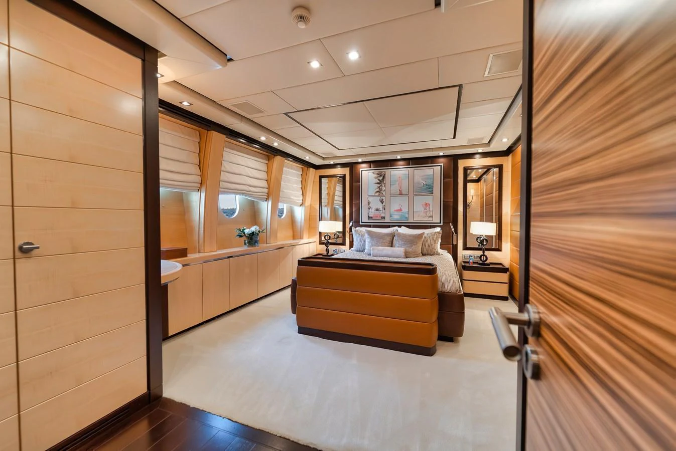 The master stateroom features a luxurious bed, elegant wood paneling, and ample natural light. aboard BET ON IT Yacht for Sale